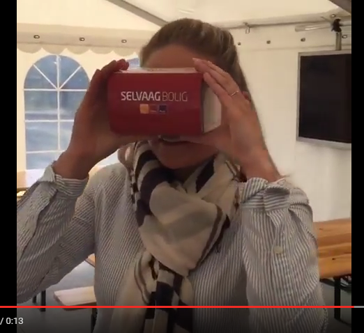 Jente prøver VR-brille med Selvaag Bolig logo